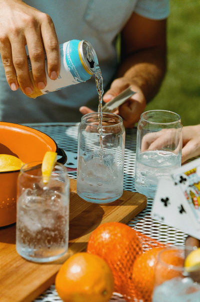 Functional beverages in a can being poured into a class.